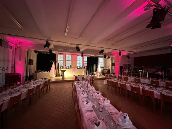 Lange Tafeln in pinkem Licht im Badhaus Rottweil