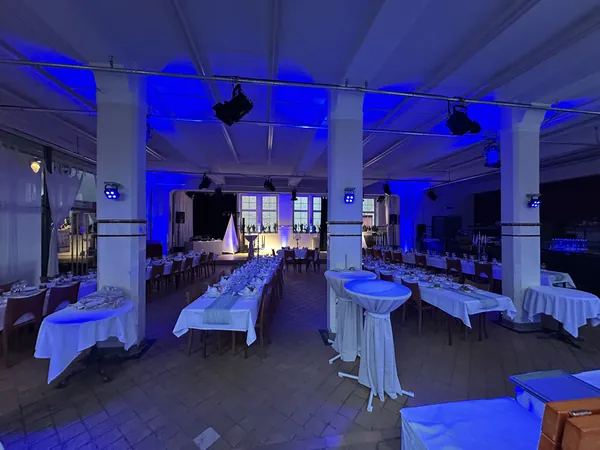 Saal in blauem Licht mit Stehtischen im Badhaus Rottweil