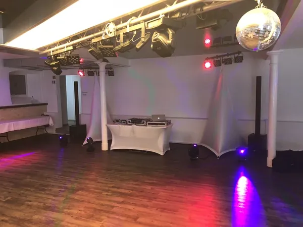Tanzfläche mit Discokugel und buntem Licht im Kuhstall des Hofgut Domäne