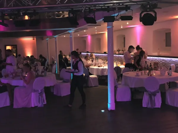 Festsaal mit rosa Ambientelicht am Abend im Hofgut Domäne