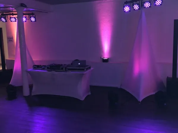 DJ-Platz in violettem Ambientelicht im Saal Kuhstall des Hofgut Domäne