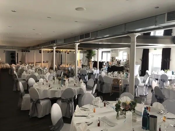 Festlich gedeckte runde Tische im Saal Kuhstall des Hofgut Domäne