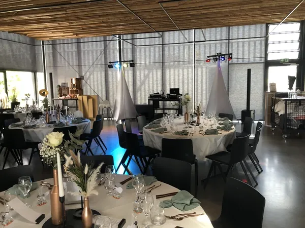 DJ-Technik mit Lichttraversen zwischen gedeckten Tischen in der Event Schneiderei