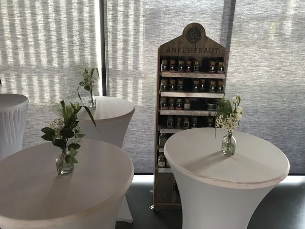 Stehtische mit Blumen und Gewürzregal im Saal der Event Schneiderei