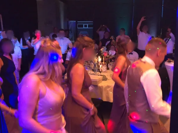 Volle Tanzfläche mit bunten Lichteffekten am Abend in der Event Schneiderei