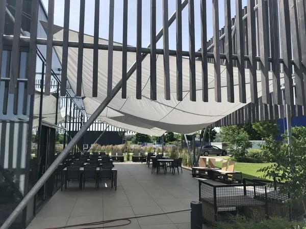 Überdachte Terrasse mit Sonnensegel und Sitzplätzen an der Event Schneiderei