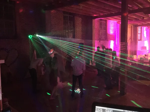 Tanzfläche mit grünen Laserstrahlen und Partylicht in der Faktorei