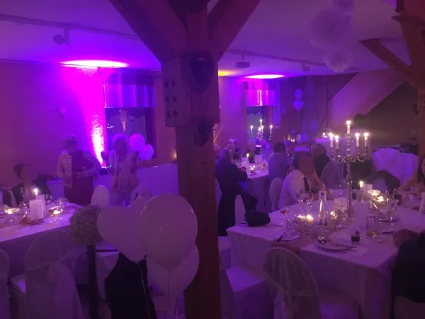 Saal mit violettem Licht und Kerzenleuchtern am Abend in Gänßle's Schuppen