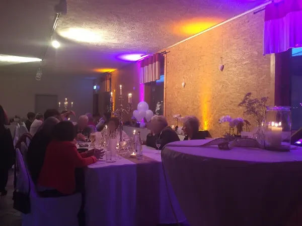 Runde Tische mit Ambientelicht an der Holzwand in Gänßle's Schuppen