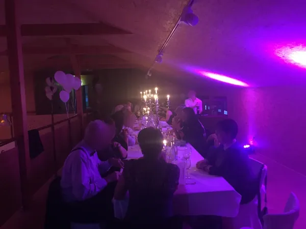 Lange Tafel im oberen Raum mit violettem Licht in Gänßle's Schuppen