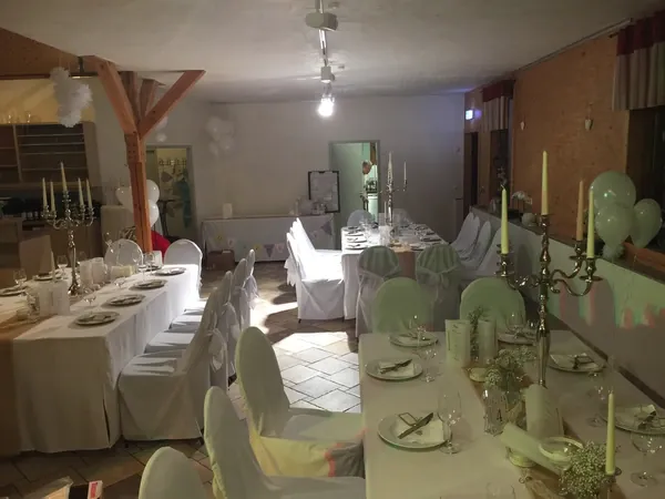 Gedeckte Tafeln mit Kerzenleuchtern und Ballons im Saal von Gänßle's Schuppen