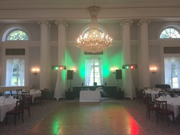 Festsaal mit Kronleuchter, Säulen und DJ-Technik im Hotel Therme
