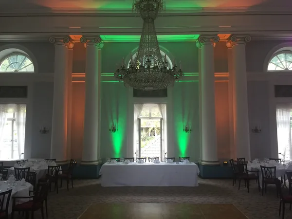 Säulensaal mit grün-orangem Licht und Kronleuchter im Hotel Therme
