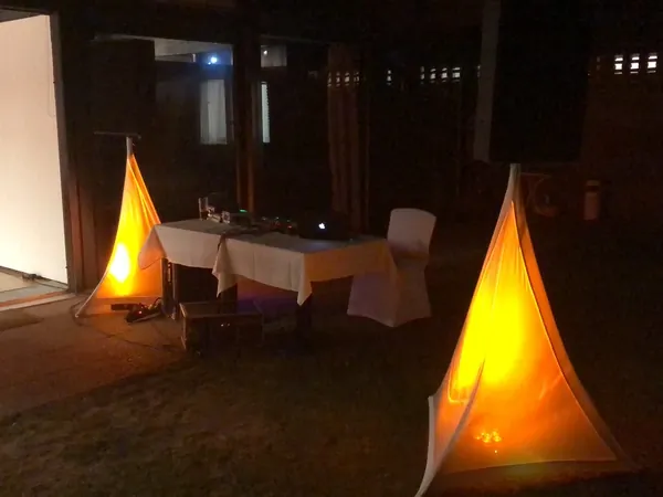 Leuchtende Stativhussen und DJ-Tisch auf der Terrasse des Kovas Balkan Restaurant bei Nacht