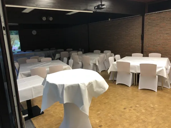 Saal mit Backsteinwand und eingedeckten Tischen im Kovas Balkan Restaurant