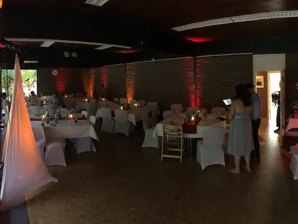 Saal mit roter Wandbeleuchtung und gedeckten Tischen im Kovas Balkan Restaurant