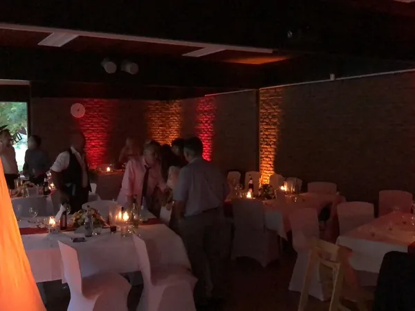 Kerzenlicht und farbig angestrahlte Backsteinwände im Saal des Kovas Balkan Restaurant