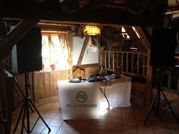DJ-Pult mit DJ-Remo-Banner im Holzgebäude des Krabba-Nescht