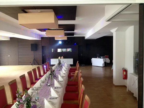 Saal mit langer Tafel und DJ-Platz im Hotel Krone