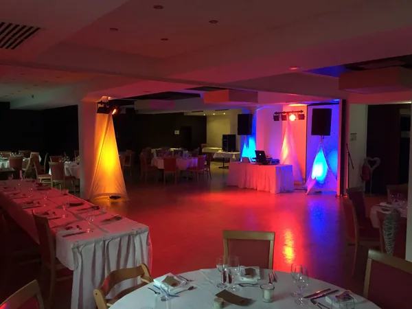 Saal mit rotem und blauem Licht und DJ-Pult im Hotel Krone