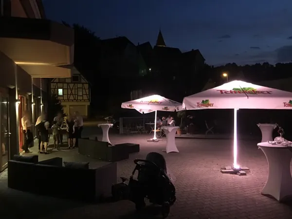 Abendlich beleuchteter Innenhof mit Stehtischen am Hotel Krone