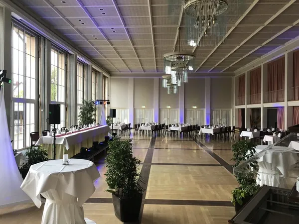 Langer Saal mit Parkettboden und hohen Fenstern im Kurhaus Freudenstadt