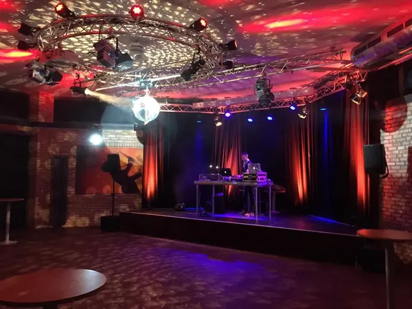 Bühne mit Partylicht, Discokugel und DJ-Pult im Mauerwerk