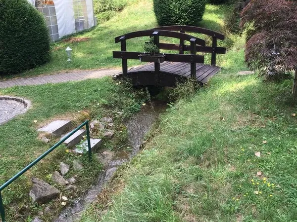 Kleine Holzbrücke über den Bach im Garten der Pfrondorfer Mühle