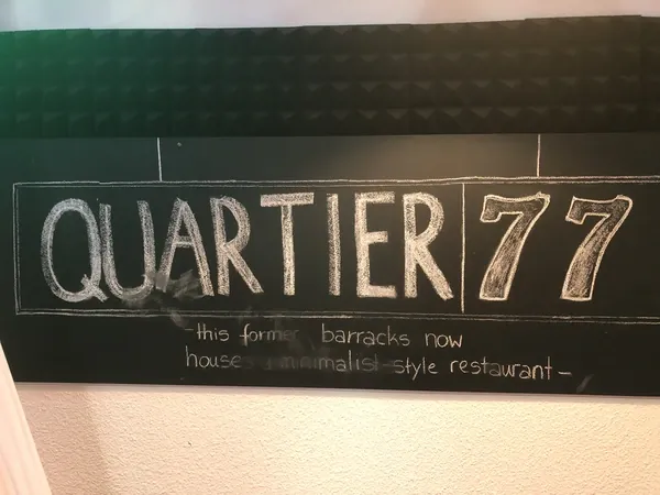 Kreidetafel mit dem Schriftzug Quartier77 im Restaurant