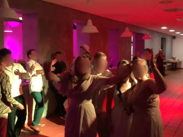 Partystimmung auf der Tanzfläche in rotem Licht im Quartier77