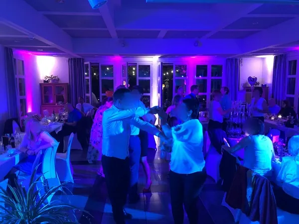 Tanzfläche zwischen den Tafeln mit violettem Ambientelicht im Römerhof