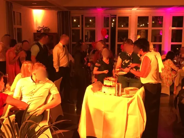 Hochzeitstorte und Kuchenbuffet im warm beleuchteten Saal des Römerhof