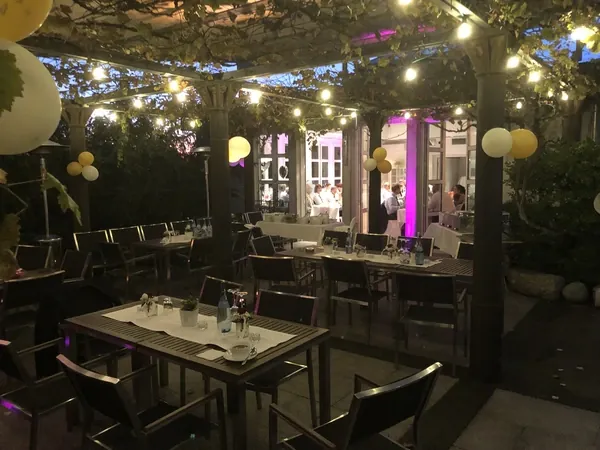 Überdachte Terrasse mit Lichterketten und gelben Ballons im Römerhof