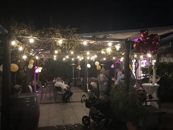 Abendliche Gartenterrasse mit Lichterketten und Herzballons am Römerhof