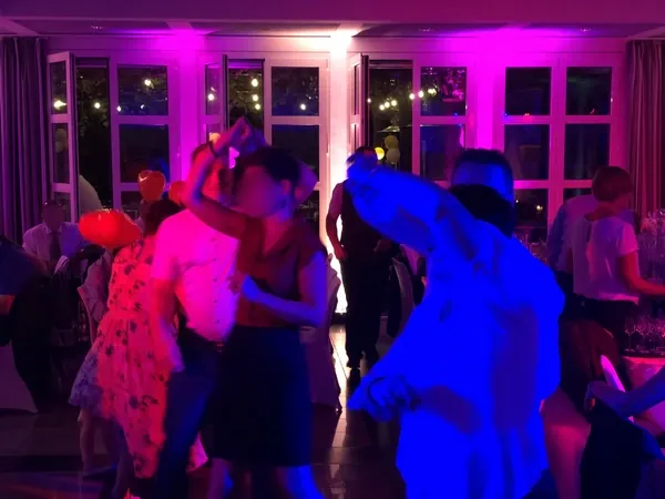 Volle Tanzfläche mit pinkem und blauem Licht im Römerhof