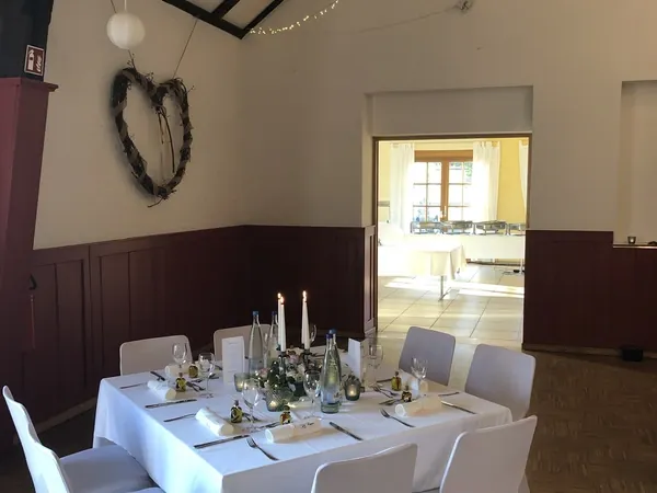 Gedeckter Tisch vor Herz-Deko und Durchgang im Schlosssaal Bühl