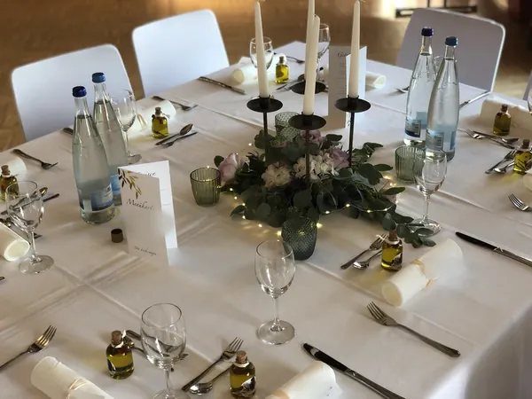 Tafel mit Kerzen, Menükarte und Olivenöl-Gastgeschenken im Schlosssaal Bühl
