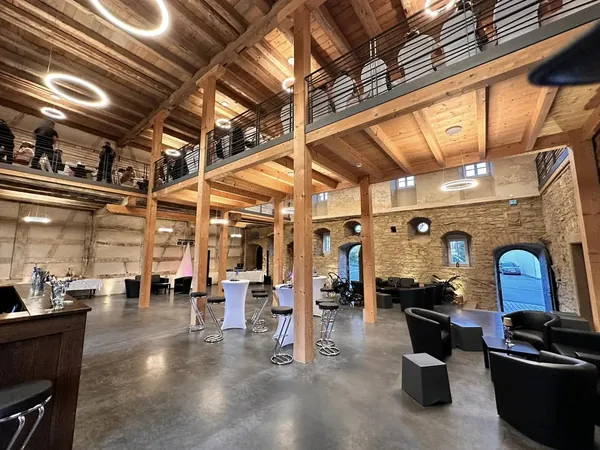Sitzbereich mit Bar und Holzgalerie im Gewölbe des Schloss Wachendorf