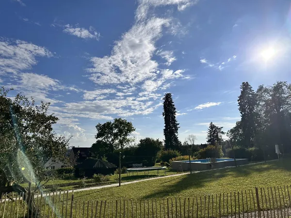 Parkwiese mit alten Bäumen und Zaun am Schloss Wachendorf