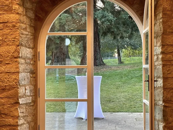 Blick durch ein Rundbogenfenster auf den Rasen des Schloss Wachendorf