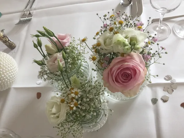 Rosa Rosen und Gipskraut als Tischdeko im Restaurant Talblick